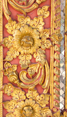 Pattern of gold flower carved on stucco design of native wall, Thai style in temple