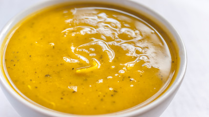 Close of white bowl with cabotia pumpkin soup