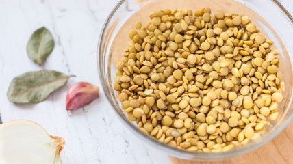 Lentil bowl with water next to onion and garlic