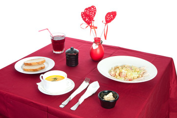 Table with served table with breakfast and drink, tablecloth red, cutlery.. Close up, indoor.