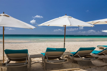 Fototapeta na wymiar Sunbeds and umbrellas on a white sand beach