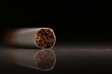 Macro shot of a cigarette on a white table over a black background