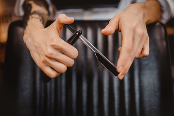 barber holds clip-on hair clipper