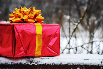 red gift box with a yellow bow, a bench in the winter park, a Christmas present, a new year, St....