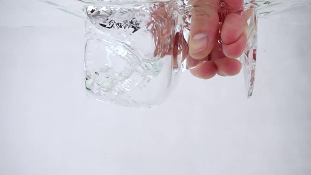 A man holds a goblet in his hand and pours water into it, close-up slow motion
