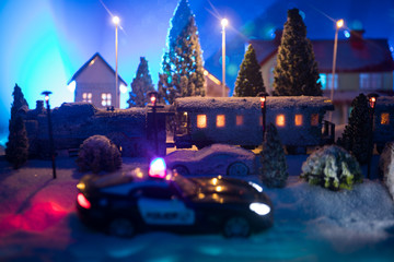 Miniature of winter scene with Christmas houses, train station, trees, covered in snow. Nights scene. New year or Christmas concept.