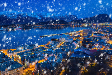 Alesund town on a cold winter night with falling snow, Norway