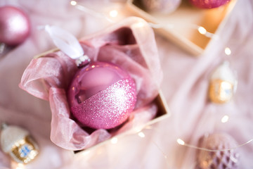 Cute pink Christmas ball in box closeup. Winter holidays. Top view.