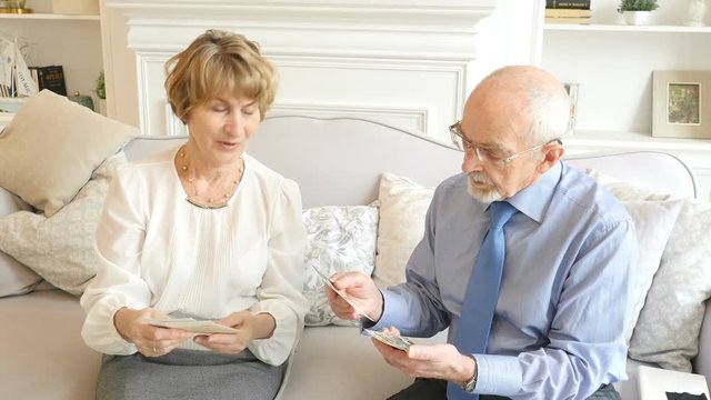 Portrait of happy attractive elderly couple watching old photos. Lovely retirement people spending time together