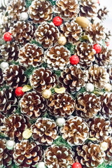 Christmas background texture of colorful red balls and pine cones closeup. Christmas holiday concept.