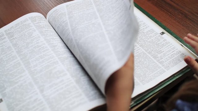 Close-up view of book. Education concept. Schoolgirl touching pages of dictionary. Smart, idea, education. Without face. Study. Inside.