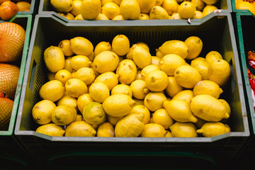 Bunch of lemons and oranges on boxes in supermarket