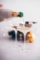 Champagne pouring into glasses and Christmas decorations
