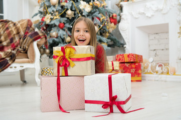 Fototapeta na wymiar Child enjoy the holiday. Decorate your Christmas with joy. Christmas tree and presents. Happy new year. Winter. xmas online shopping. Family holiday. The morning before Xmas. Little girl