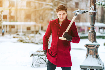 Young man holding shovel outdoors