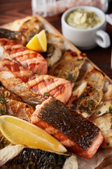 Assorted grilled fish on wooden board