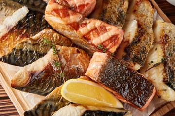 Assorted grilled fish on wooden board