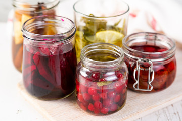 Fototapeta na wymiar Preparing drinking vinegar infusions in glass jars, copy space