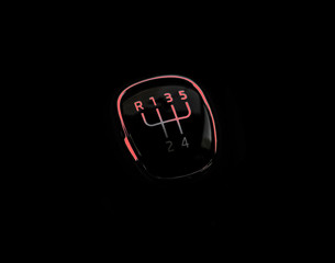 Manual transmission gear shift, on dark backgroun with red light. Close-up