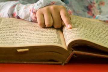 Fototapeta premium girl read the Koran while pointing to the verses she read