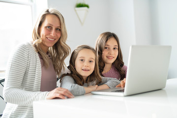 A Nice mom spend time with kids watching educational programs on laptop