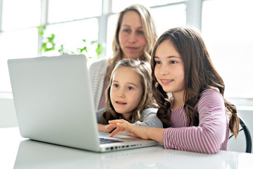 A Nice mom spend time with kids watching educational programs on laptop