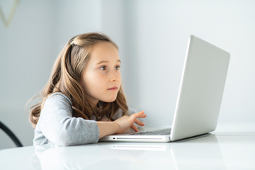 A Young girl using laptop at home