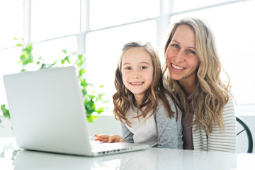 A Nice mom spend time with kid watching educational programs on laptop