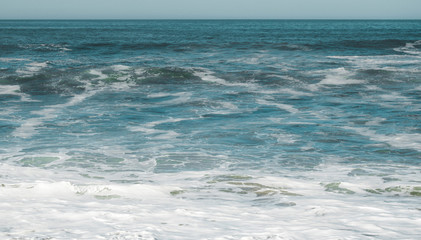 Obraz premium Clear, blue sea water in Morocco with sea foam in the front