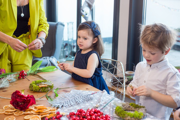 Siblings making Christmas decorations. Lifestyle image, shallow depth of field.