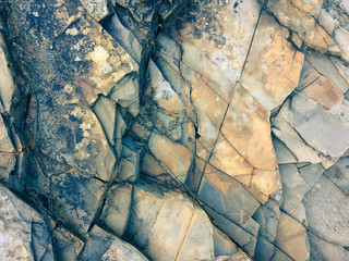 fractured rock strata as a background, cracked rock, stone texture, many cracks in the stone,...