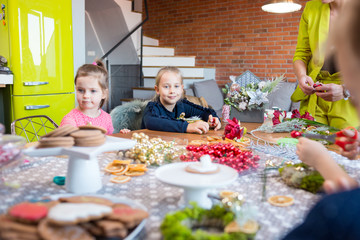 Siblings making Christmas decorations. Lifestyle image, shallow depth of field.