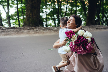 Fototapeta premium Happy mother with her young son in a summer park.