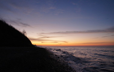 Sonnenuntergang am Strand mit Wellen und Sand an der Ostsee nahe Warnem&uuml;nde im Urlaub