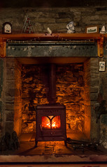 Wood burning stove with in a stone fireplace, with Christmas decorations