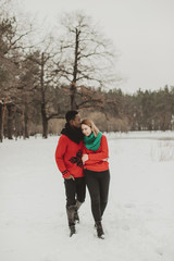  young couple in love walks through the winter forest and kiss