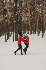  young couple in love walks through the winter forest and kiss