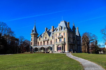 Fototapeta na wymiar Schadau Castle, built in 1846 - 1854, on the shore of Lake Thun in Switzerland, features romantic and neo-Gothic stylistic elements and is surrounded by a large English garden