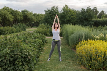 Young happy sporty woman stretching after jogging exercise in the city park