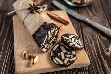 Chocolate sachocolate; sausage; background; wooden; baked; biscuit; board; breakfast; brown; butteusage on a wooden background. Dessert made of biscuits, chocolate and nuts is sliced on a wooden board