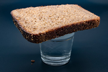 Traditional food and drink for a dead man on Russian funeral or commemoration: glass of vodka...