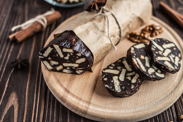 Chocolate sachocolate; sausage; background; wooden; baked; biscuit; board; breakfast; brown; butteusage on a wooden background. Dessert made of biscuits, chocolate and nuts is sliced on a wooden board