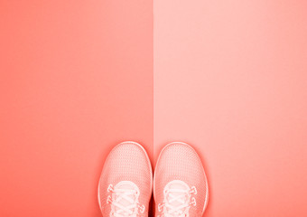 Sport shoes (sneakers) on background in Living coral color with copy space. Color of the year 2019....