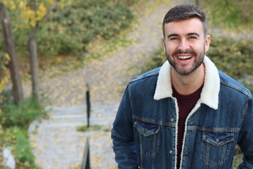 Natural man smiling outdoors with copy space