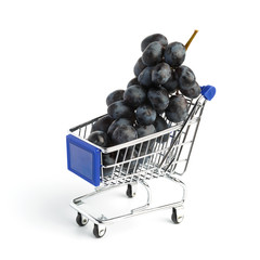 Bunch of ripe black grapes in the grocery cart on a white background. Conceptual photo
