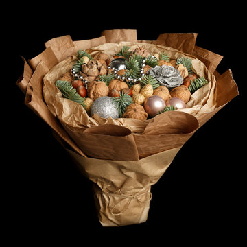 Beautiful Christmas decorative bouquet of various nuts, decorated with twigs of Christmas tree and balls on black background