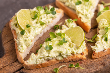 Toasts with avocado pate, fresh microgreen and lime