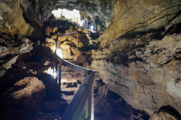 Enlighted lava tunnel with humid floor in the Galapagos island of Sand Cruz on the way to Puerto...