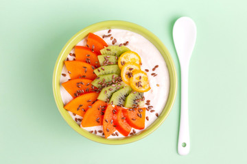 Acai bowl with vanilla smoothie, fresh persimmon, kiwi, kumquat