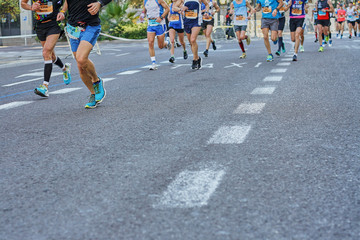 Marathon race, feet of people running on city road